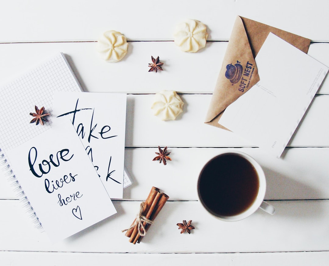 Notebook, coffee, and cookies on white wooden table
