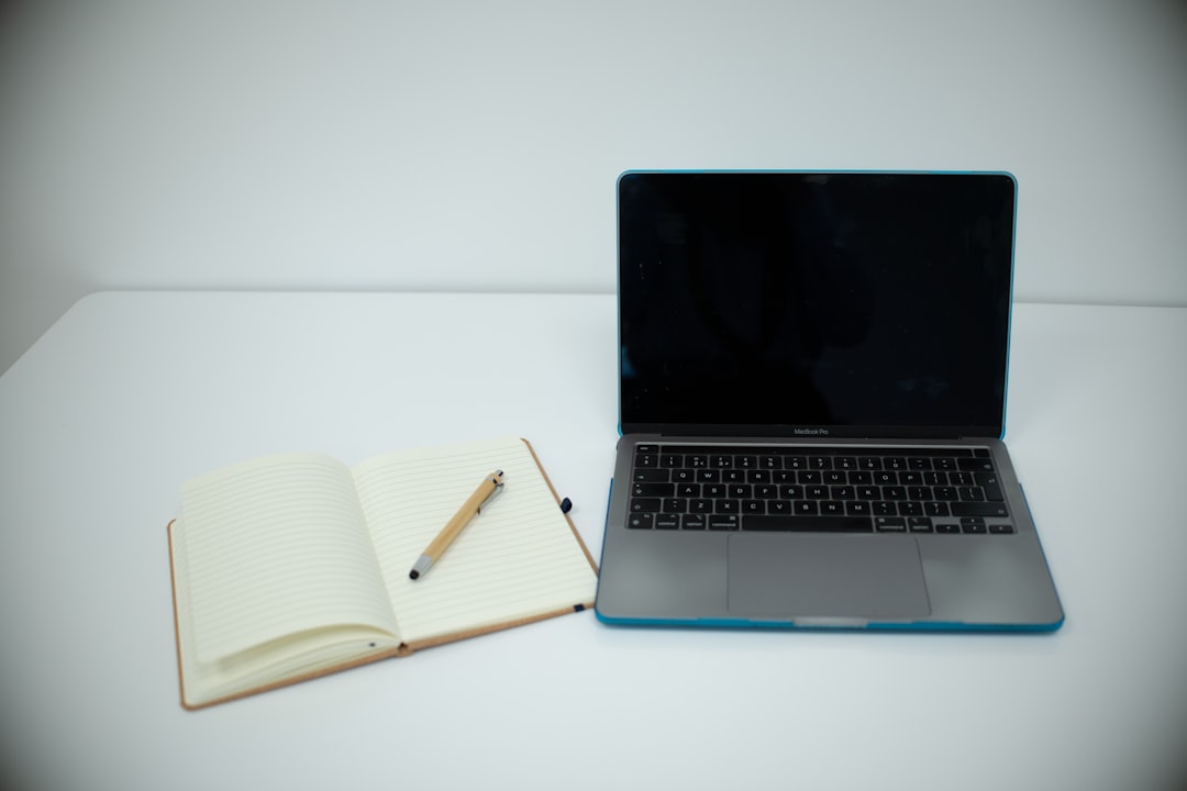 Laptop and open notebook on a clean desk where I draft B2B SaaS proposals