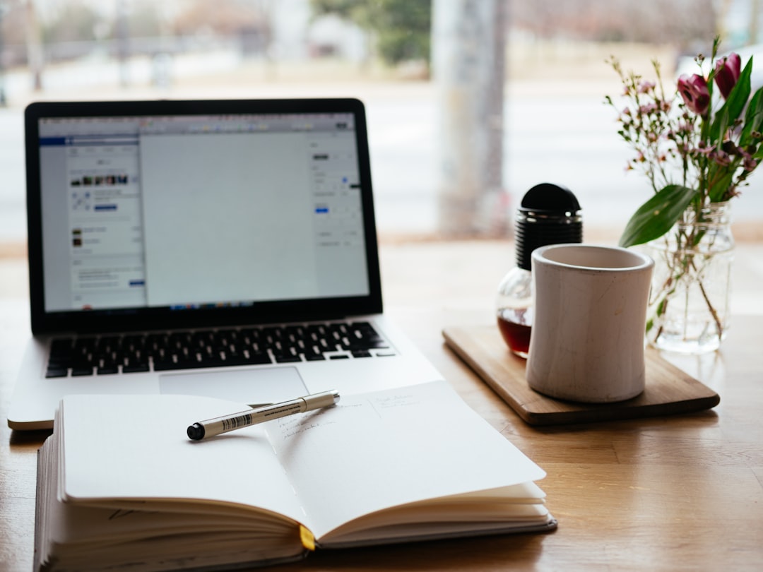 Notion AI meeting notes on a laptop beside an open notebook in a minimal productivity workspace