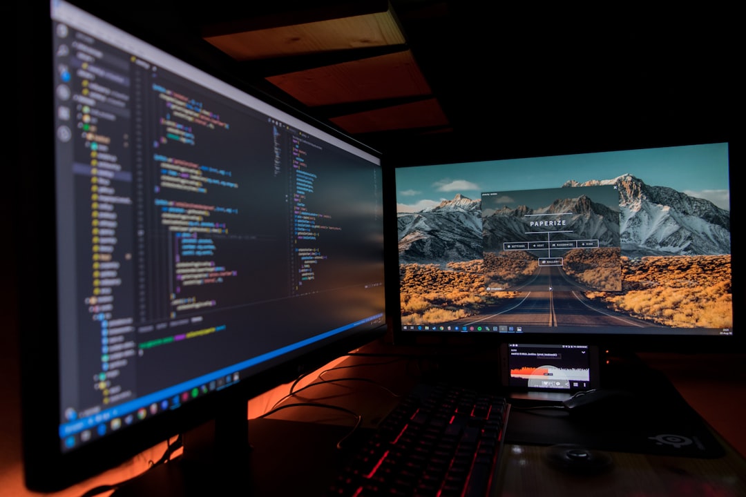 Two desktop monitors showing code, illustrating Mac Studio M5 Ultra AI news for local model work
