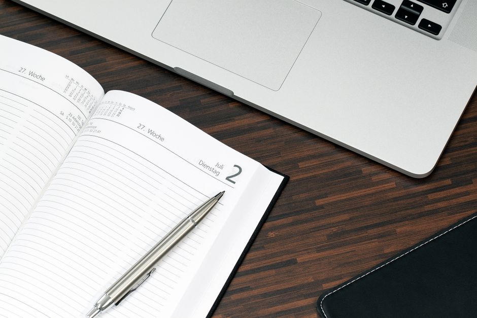 Open planner and laptop desk visual for Notion Custom Agents Productivity coverage